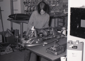 A model maker works on Joe 90's car with the Thunderbirds in the background